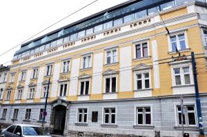 een geel en wit gebouw met een auto voor de deur bij Traditional Slovak Apartment in Bratislava