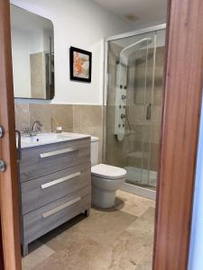 a bathroom with a toilet and a sink and a shower at Chalet Adosado en Playa La Barrosa in Novo Sancti Petri +17 photos