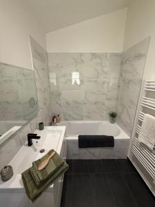 a white bathroom with a tub and a sink at Les Jujubiers in Draguignan