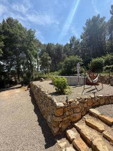 a stone retaining wall with a bench in a garden at Les Jujubiers in Draguignan