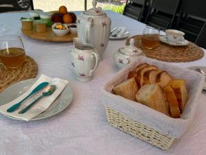 a table with a basket of bread and glasses of tea at Les Jujubiers in Draguignan +9 photos