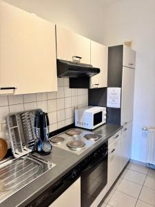 a kitchen with a microwave and a stove top oven at Pension Sellent in Stendal