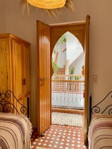 a room with two beds and a doorway with a balcony at Dar Dada Riad climatisé à votre disposition dans sa totalité et de façon exclusive in Safi