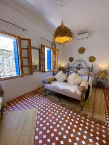 a bedroom with a bed and a checkered floor at Dar Dada Riad climatisé à votre disposition dans sa totalité et de façon exclusive in Safi