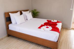 a large bed with red and white bows on it at Hotel National Ambanja in Ambanja