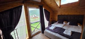 a bedroom with a bed and a large window at Swiss House Dilijan in Dilijan