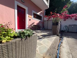 a house with a red door and some plants at Corfu Port Sweet Home in Mantoúkion