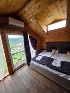 a bedroom with a bed and a large window at Swiss House Dilijan in Dilijan