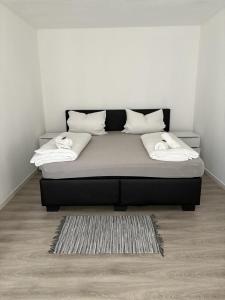 a black bed with white pillows and a rug at Ferienwohnung Soltau in Soltau