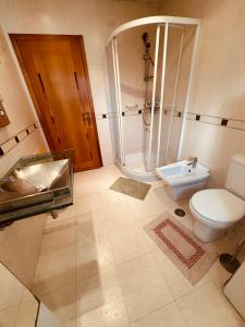 a bathroom with a toilet and a shower and a sink at Rua Gama Barros 22 SUITE in Charneca
