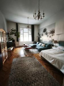 a bedroom with a bed and a living room at The Stage Door Apartment in Debrecen