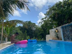 a man and a child sitting in a swimming pool at Villa Esperanza in San Cristóbal