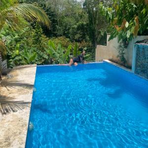 a man laying on the side of a blue swimming pool at Villa Esperanza in San Cristóbal +9 photos