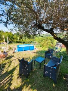 a group of chairs and a table under a tree at Alloggio DON ESTEBAN in Santa Maria della Versa