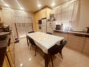 a kitchen with a white table and chairs in a kitchen at Rua Gama Barros 22 SUITE in Charneca