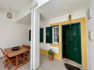 a green door in a room with a table at Milfontes Villa in Vila Nova de Milfontes +22 photos