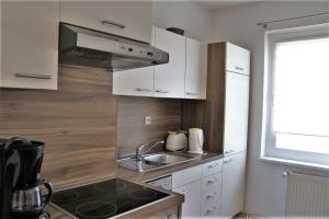 a kitchen with white cabinets and a sink at Ferienwohnung in Reuterstadt Stavenhagen