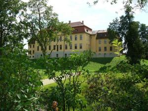 a large building in the middle of a field with trees at Ferienwohnung in Reuterstadt Stavenhagen +18 photos