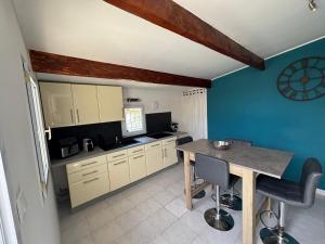 a kitchen with a wooden table and a blue wall at My Pradet in Le Pradet
