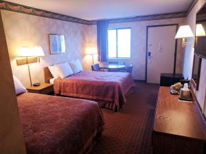 a hotel room with two beds and a table at Value Inn Harrisburg-York in Valley Green