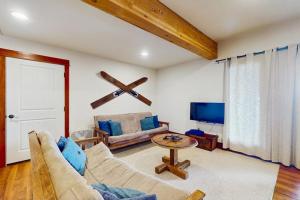 a living room with a couch and a tv at Bottle Bay Lakefront Lodge in Sandpoint