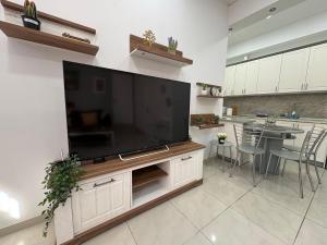 a large flat screen tv on a wall in a kitchen at Corfu Port Sweet Home in Mantoúkion