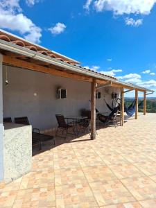 a patio with a roof with chairs and a table at Flat por do Sol in Tiradentes