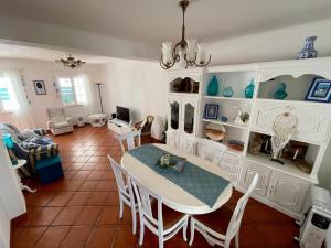 a dining room and living room with a table and chairs at Milfontes Villa in Vila Nova de Milfontes