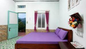 a bedroom with a purple bed and a window at Sapa Tatu Homestay in Sapa +104 photos