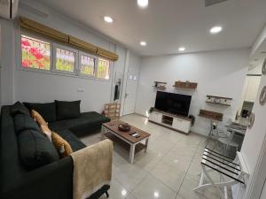 a living room with a green couch and a tv at Corfu Port Sweet Home in Mantoúkion