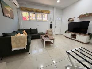 a living room with a couch and a tv at Corfu Port Sweet Home in Mantoúkion +18 photos