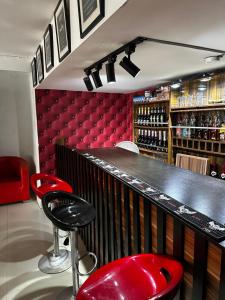 Eine Bar mit zwei roten Barhockern und einer roten Bank in der Unterkunft Solitaire hotel in Lagos