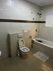 ein Badezimmer mit Toilette und Badewanne in der Unterkunft Solitaire hotel in Lagos