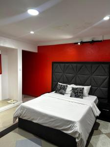 ein Schlafzimmer mit einem großen Bett und einer roten Wand in der Unterkunft Solitaire hotel in Lagos