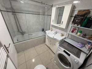 a bathroom with a shower sink and a washing machine at Corfu Port Sweet Home in Mantoúkion