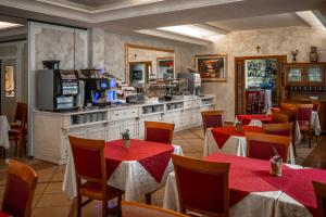 a restaurant with tables and chairs and a kitchen at Hotel Confine in Colà di Lazise