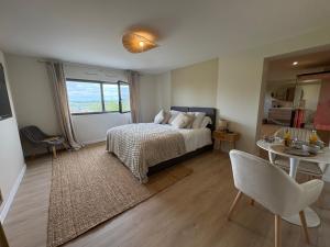 a bedroom with a bed and a table and a chair at Bergerie bien être in Vaivre-et-Montoille