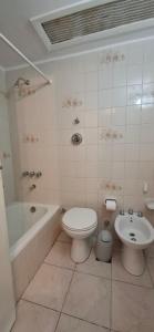 a bathroom with a tub and a toilet and a sink at El encanto del lago in San Carlos de Bariloche