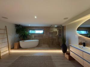 a large bathroom with a tub and a sink at Bergerie bien être in Vaivre-et-Montoille +26 photos