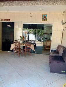 a patio with a table and chairs and a couch at Pousada Rota da Luz in Aparecida