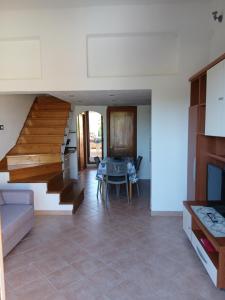 a living room with a staircase and a table at Casa SILMAGA in La Maddalena