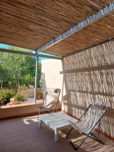 two chairs and a hammock on a patio at Casa SILMAGA in La Maddalena