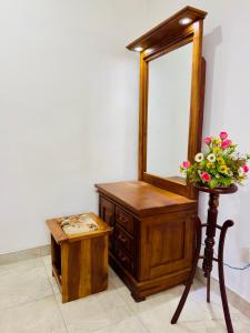 a wooden dresser with a mirror and a wooden stool at The Travellers Rest in Katunayaka