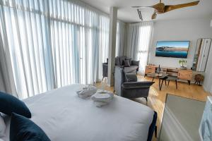 a bedroom with a white bed and a living room at yoga Lake view in Had Nes