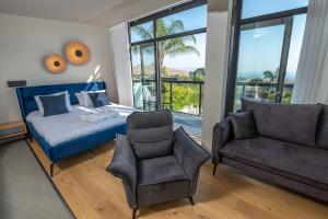 a bedroom with a bed and a couch and a chair at yoga Lake view in Had Nes