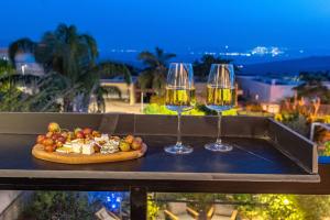 two wine glasses and a plate of food on a table at yoga Lake view in Had Nes