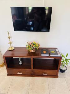 a wooden cabinet with flowers on top of it at The Travellers Rest in Katunayaka