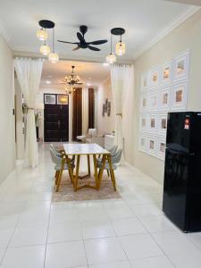 a dining room with a table and some chairs at Elora Homestay in Tampin