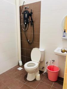 a bathroom with a toilet and a shower at Elora Homestay in Tampin