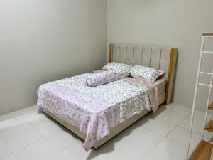 a bedroom with a bed with pillows on it at Elora Homestay in Tampin